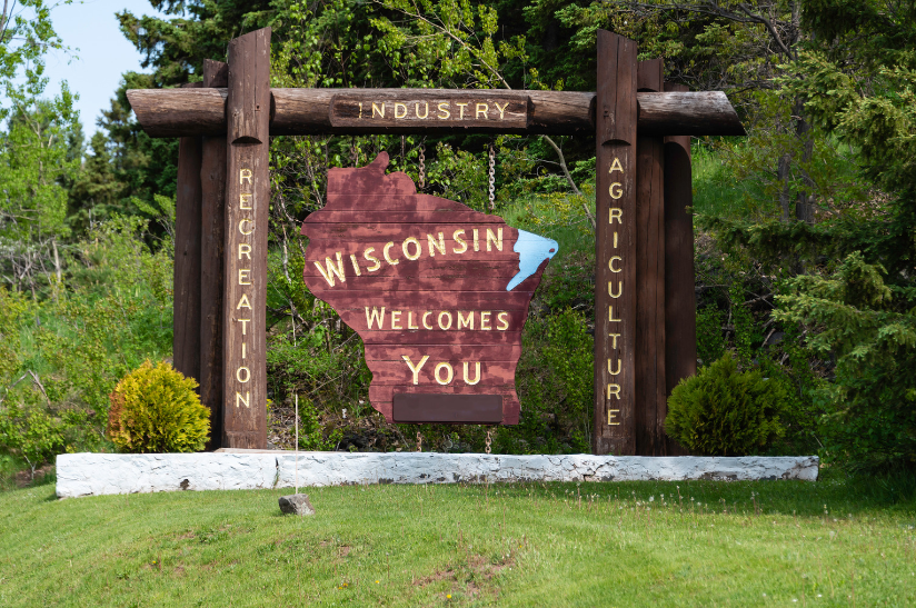 A wooden sign that says wisconsin welcomes you