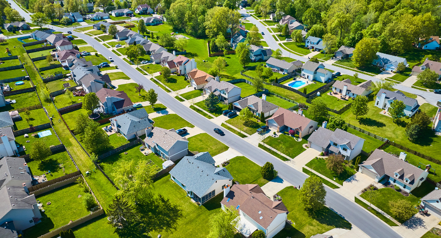 An aerial view of a residential neighborhood with lots of houses and trees.