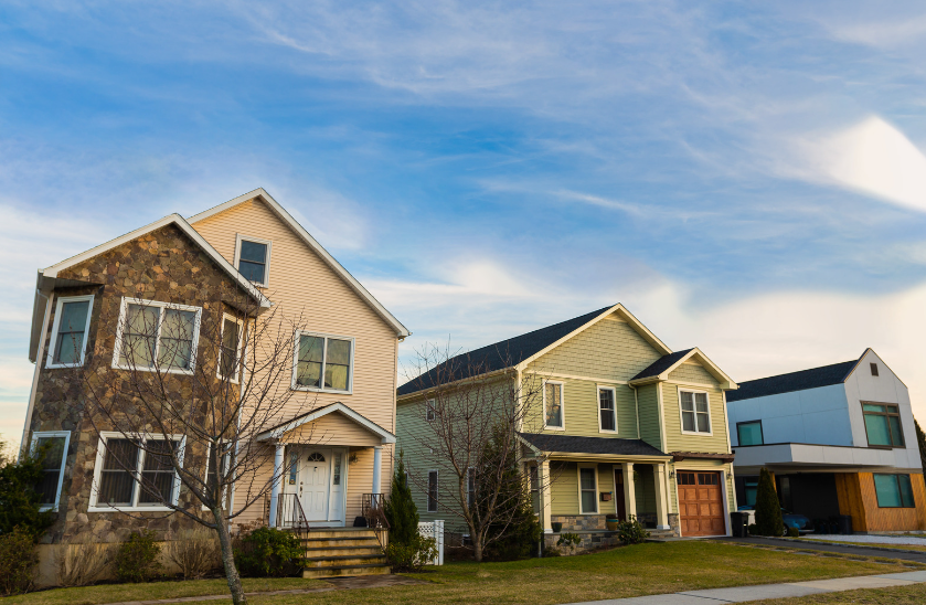 A row of houses on a sunny day with a blue sky in the background.