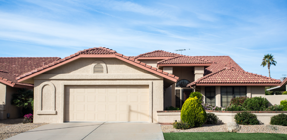 A large house with a red tile roof and a large garage.