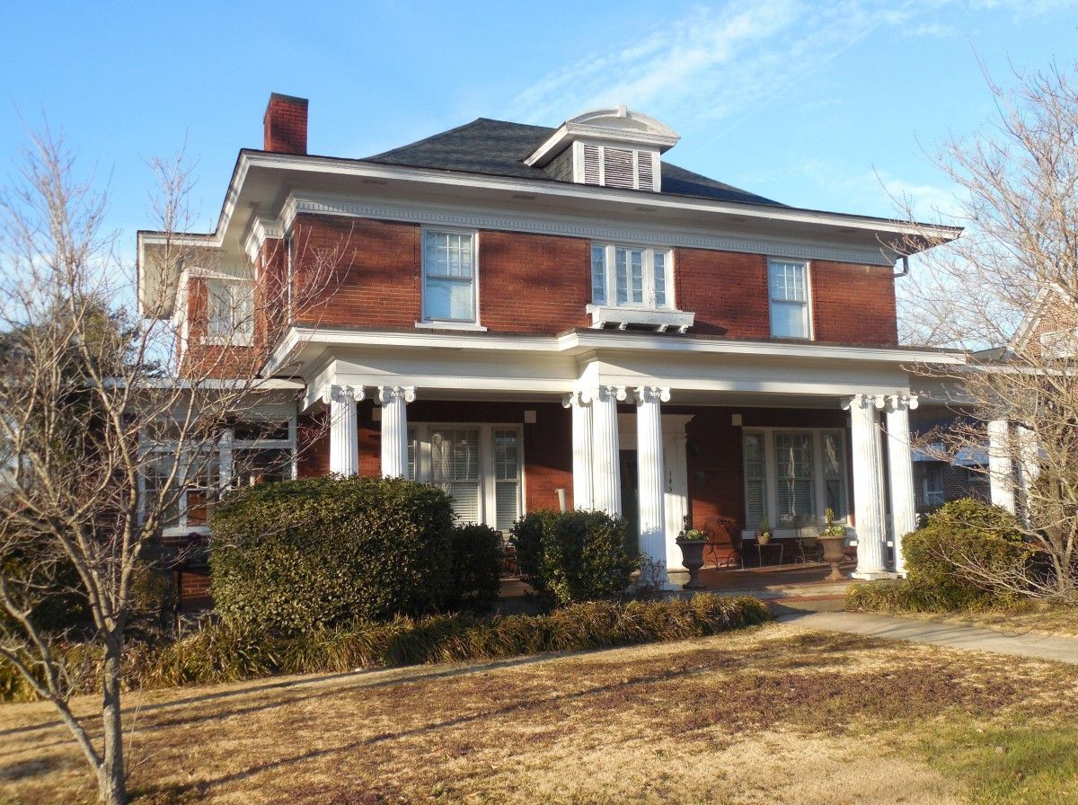 A large brick house with a porch and columns