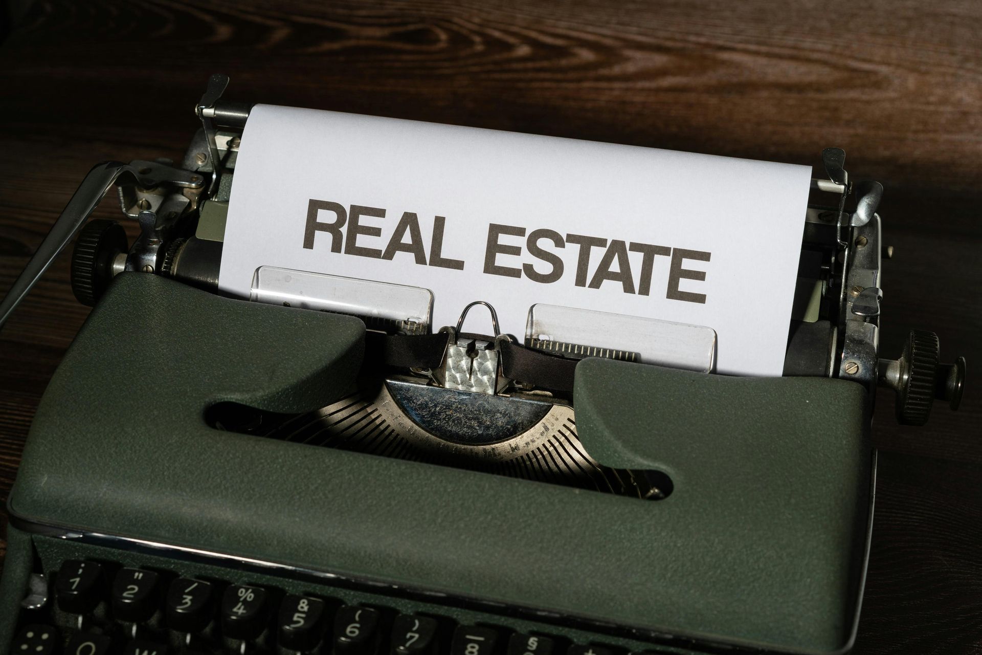 A typewriter with a piece of paper that says real estate on it