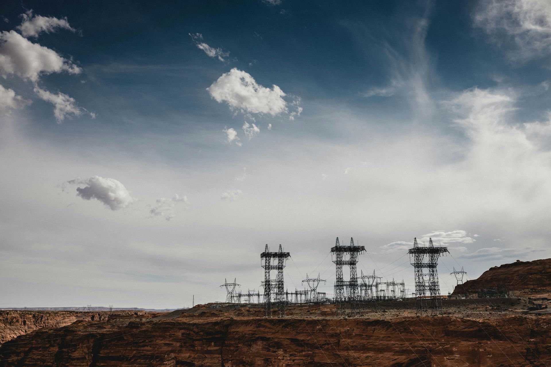 A row of power lines sitting on top of a hill.