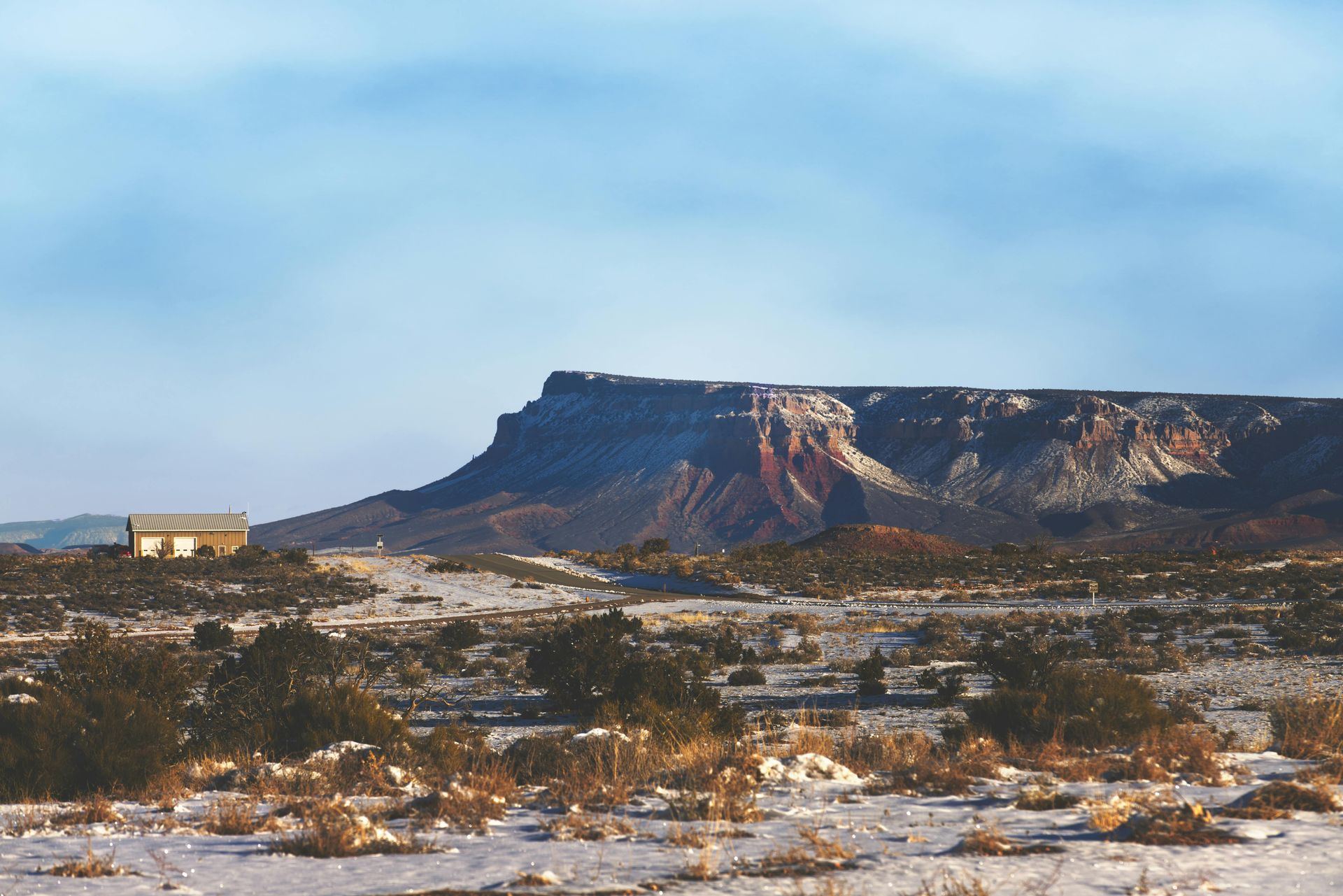 A snowy desert landscape with a mountain in the background