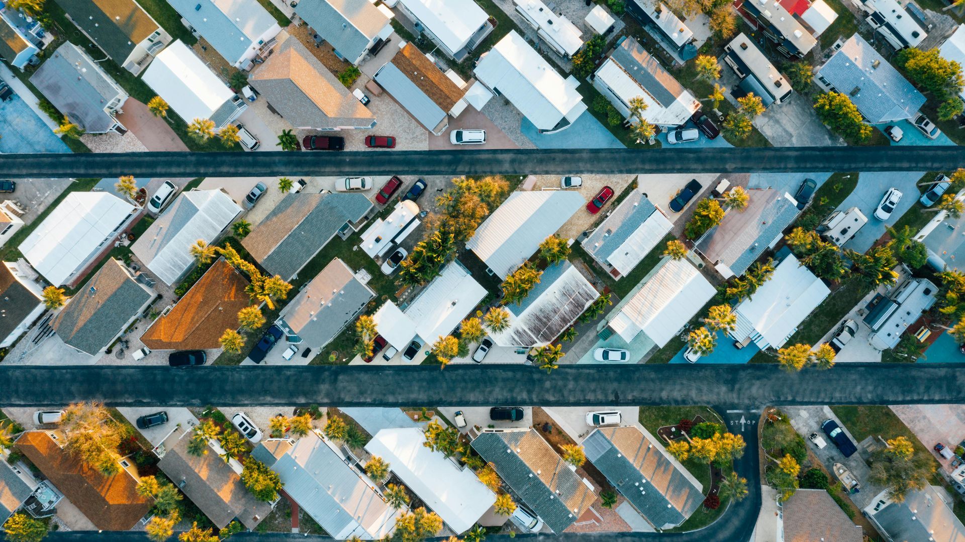 An aerial view of a residential area with lots of houses and cars.