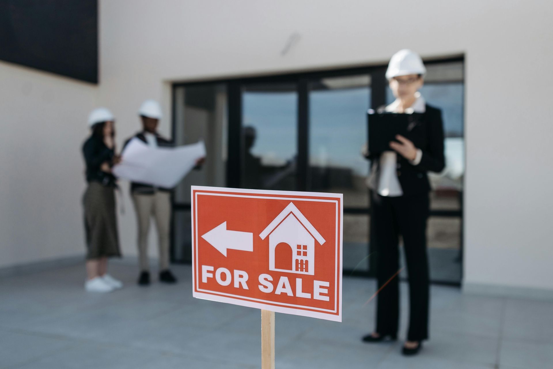 A for sale sign is in front of a building.