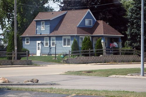 A blue west allis house with a fence in front of it