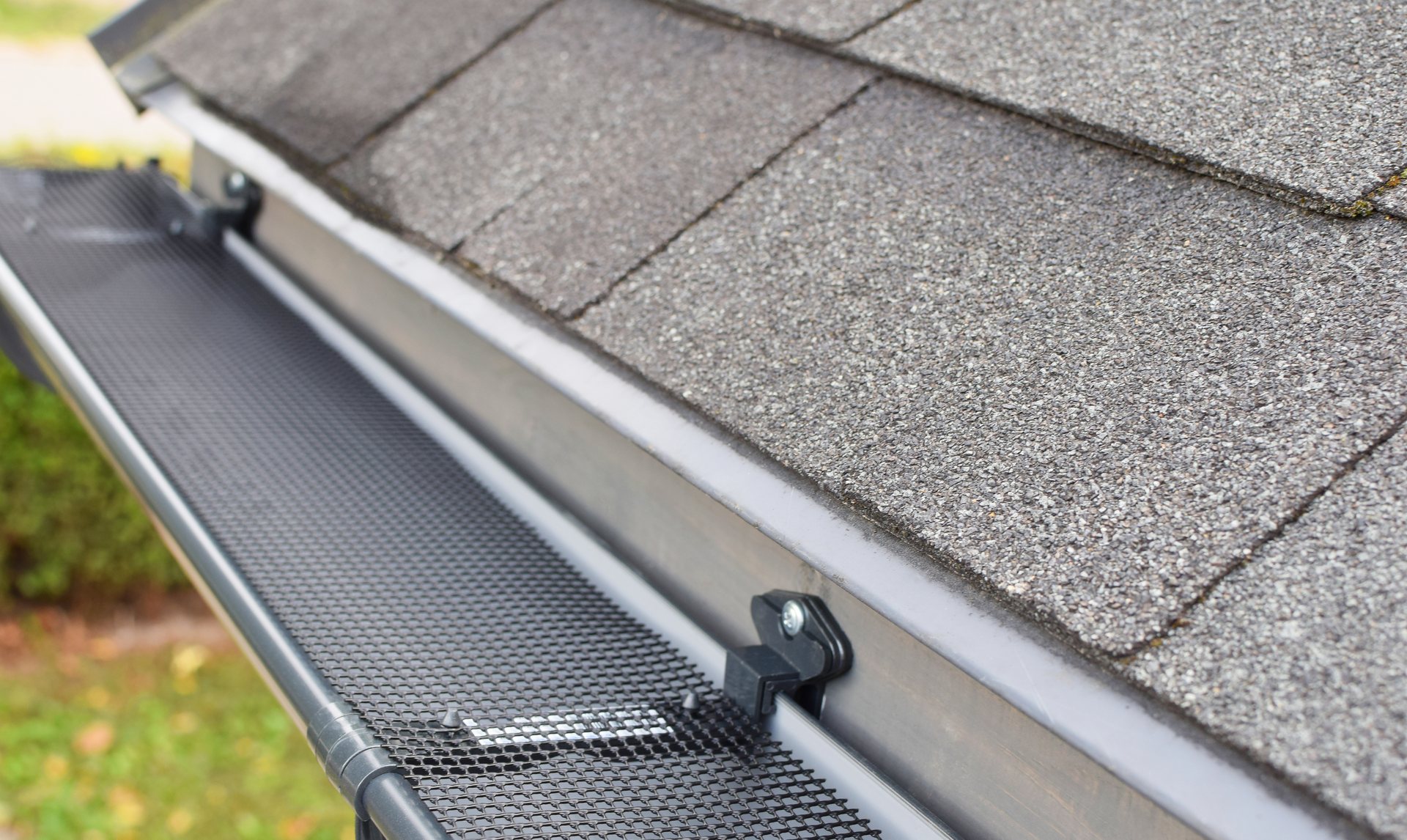 Gutter with mesh screen installed on a roof, protecting against debris.
