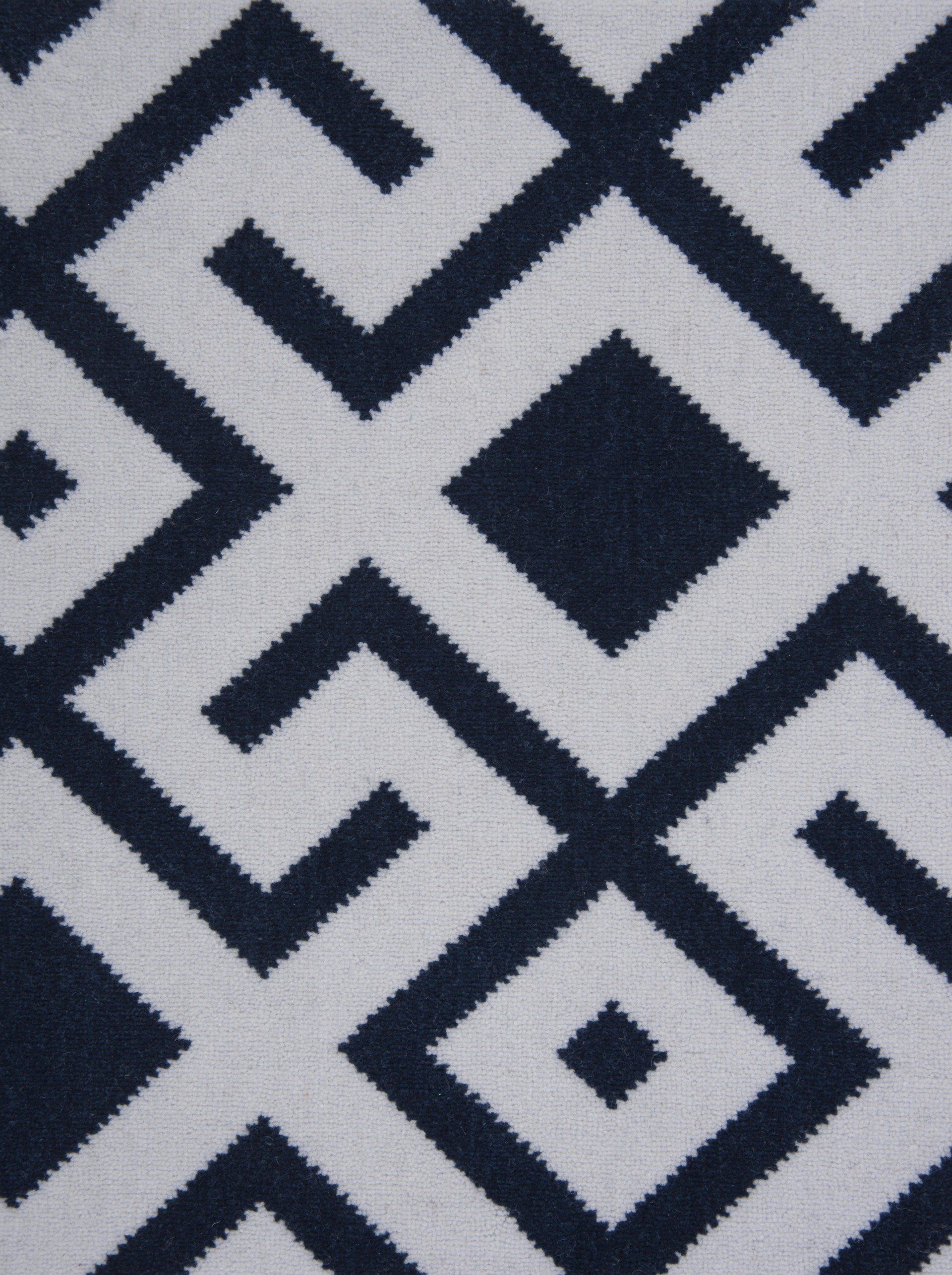 Geometric blue and white pattern with diamonds and angled lines.