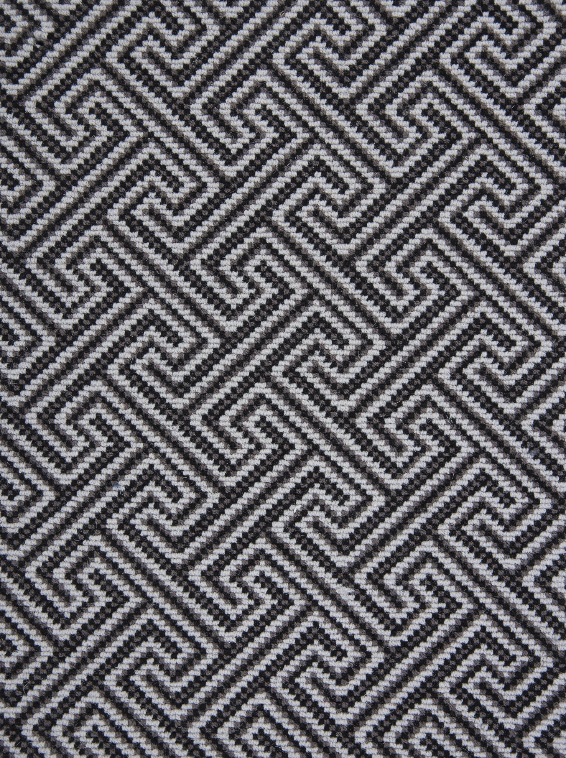 Black and gray woven fabric with a repeating maze-like pattern.