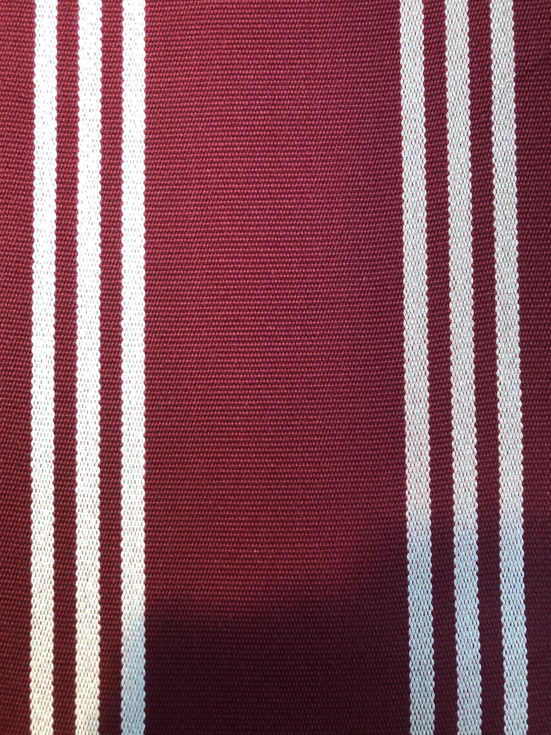 Maroon fabric with vertical white stripes.