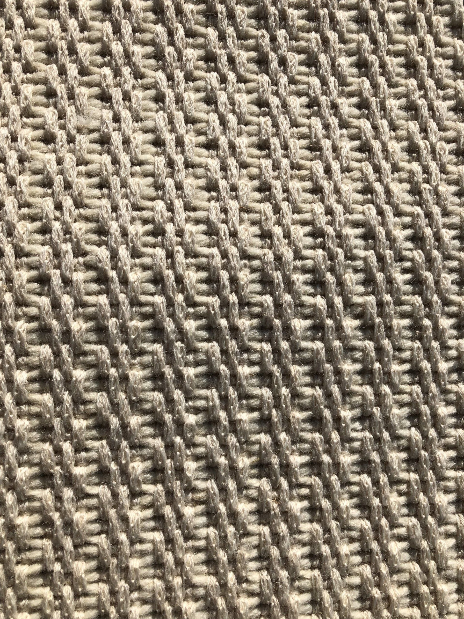 Close-up of beige woven texture with diagonal pattern.