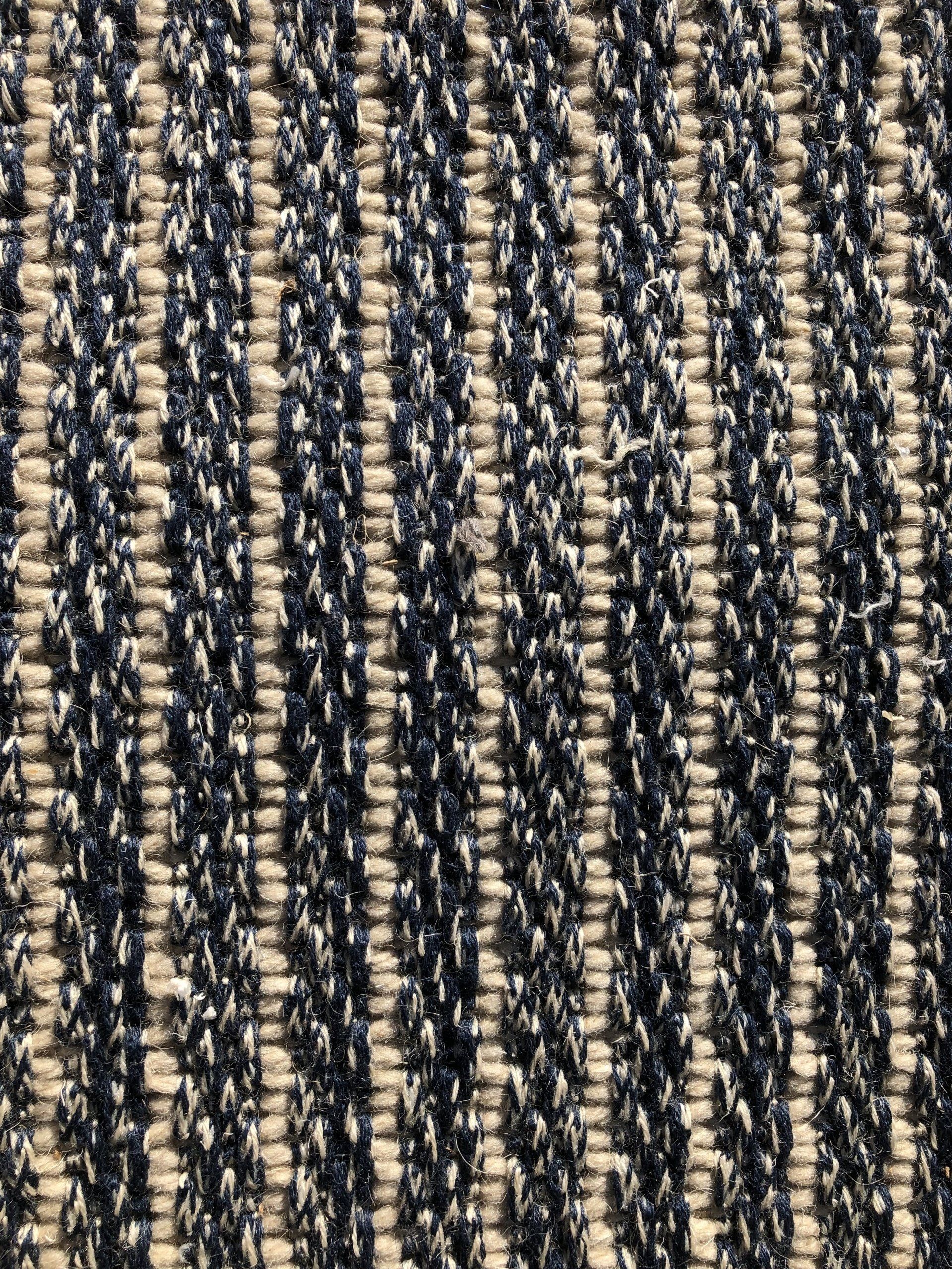 Close-up of a woven textile with vertical stripes of navy blue and off-white.