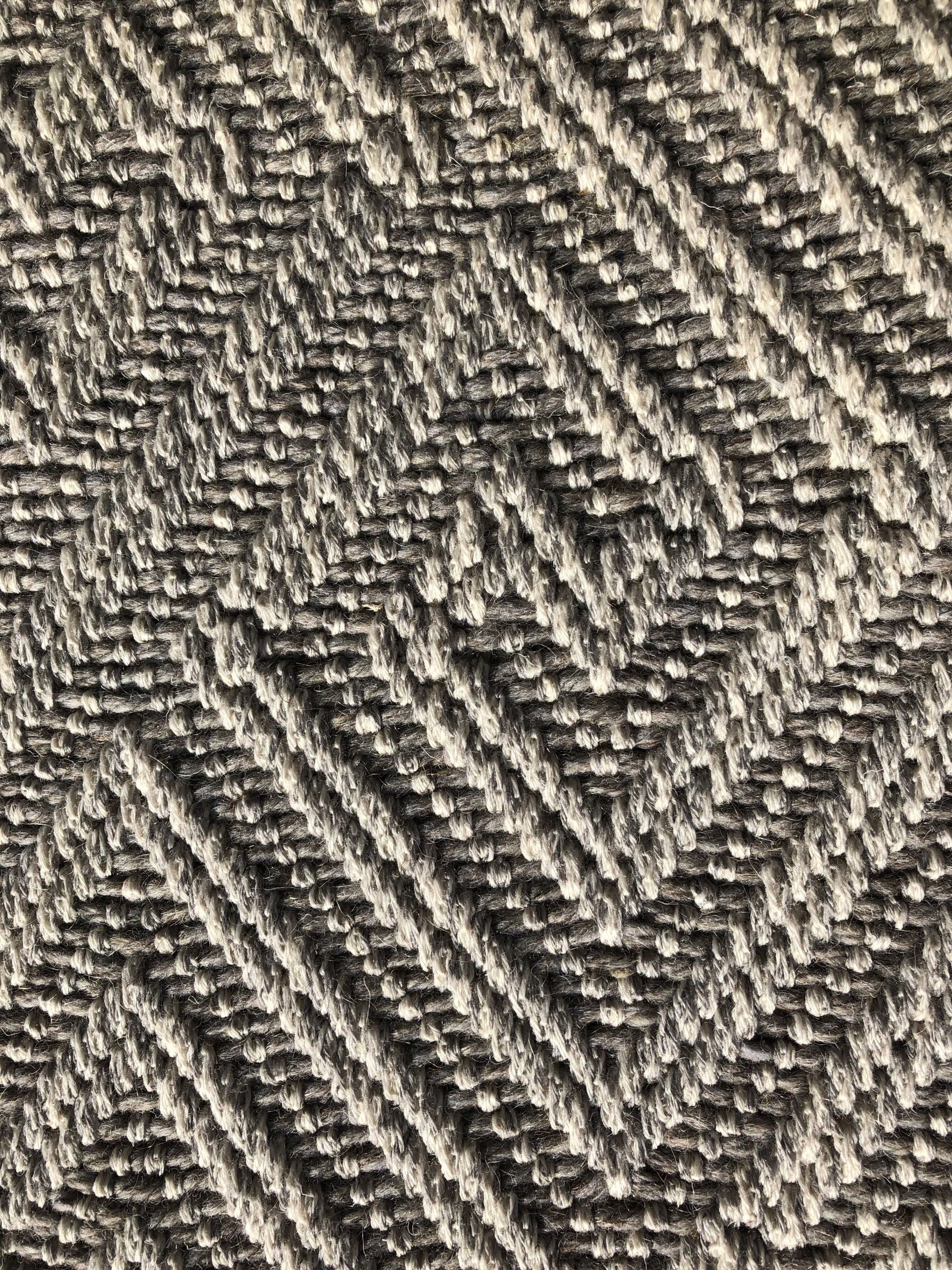 Close-up of gray and off-white herringbone patterned fabric.