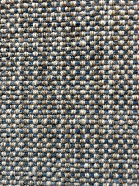 Close-up of woven fabric with alternating light beige and dark blue-gray squares.