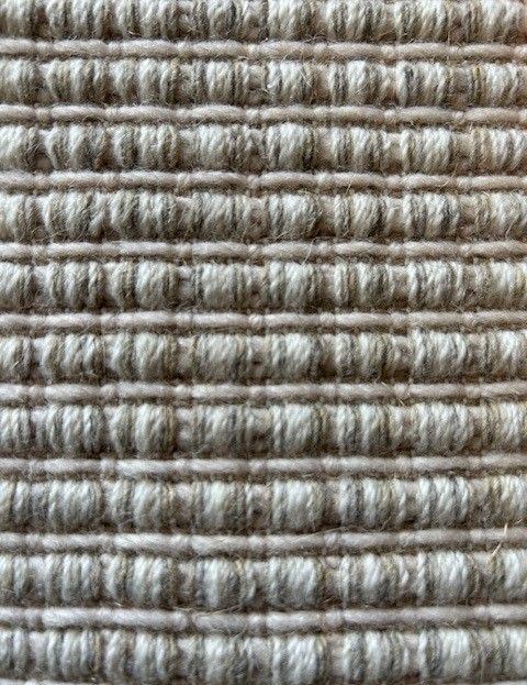 Close-up of beige woven fabric with horizontal ribbed texture.