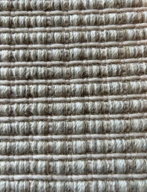 Close-up of woven fabric with a textured, ridged pattern in neutral beige and brown tones.