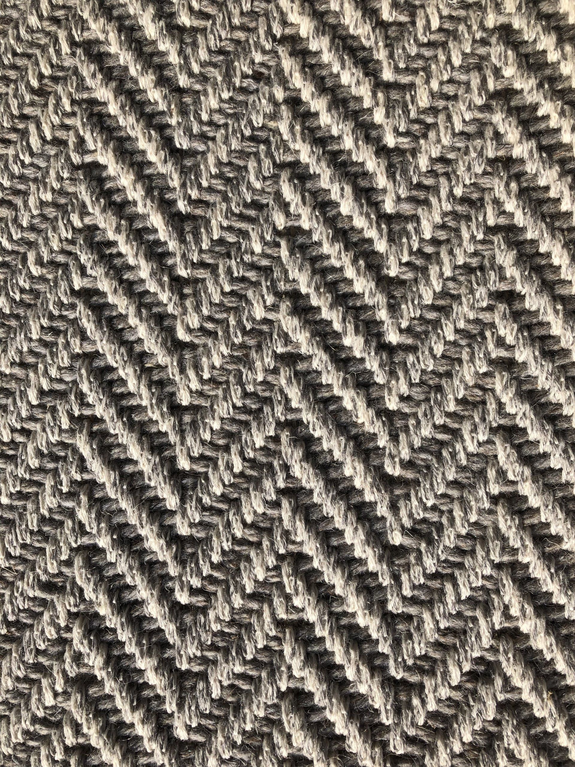 Herringbone pattern carpet in shades of gray and white.