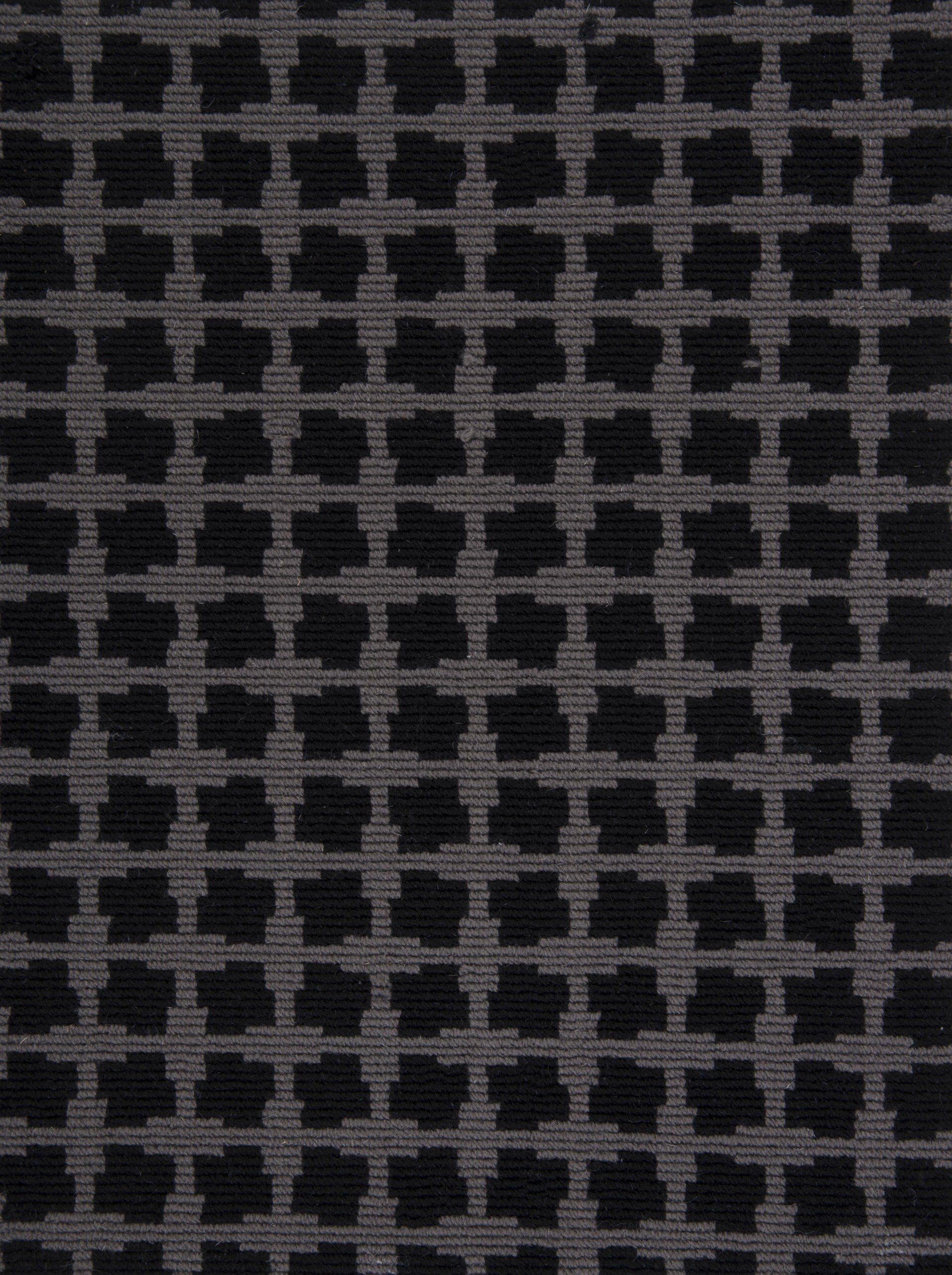 Dark gray fabric with a repeating grid pattern of black quatrefoils.