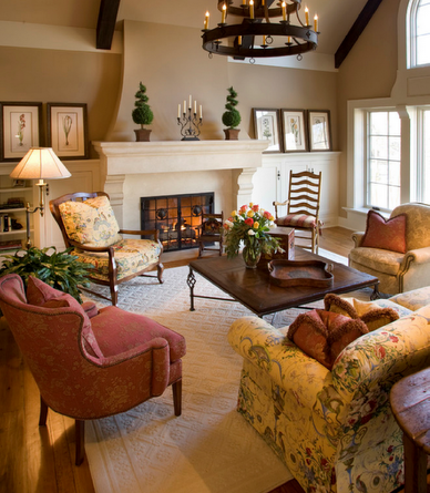 Cozy living room with fireplace, floral patterned furniture, neutral walls, and a chandelier.