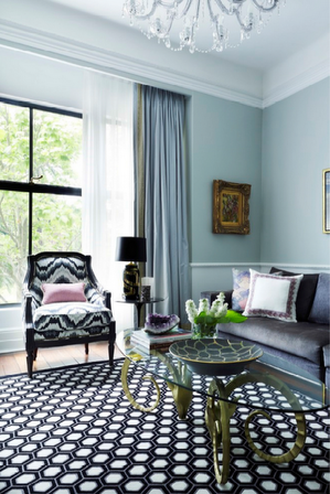 Elegant living room with patterned rug, patterned chair, and blue walls.