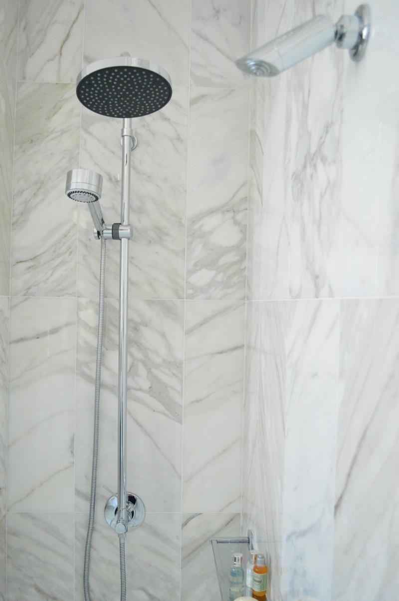 A close up of a shower head in a bathroom.