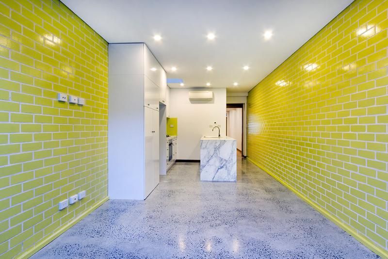 An empty room with yellow brick walls and a marble counter top