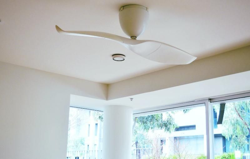 A white ceiling fan is hanging from the ceiling in a living room.