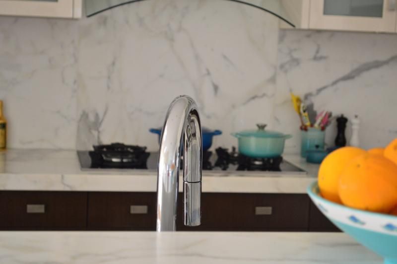 A kitchen with a bowl of oranges on the counter