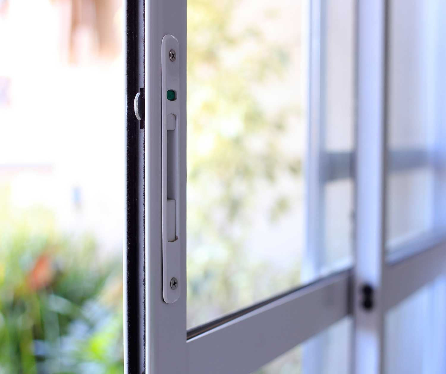 A close up of a sliding glass door with a screen door.