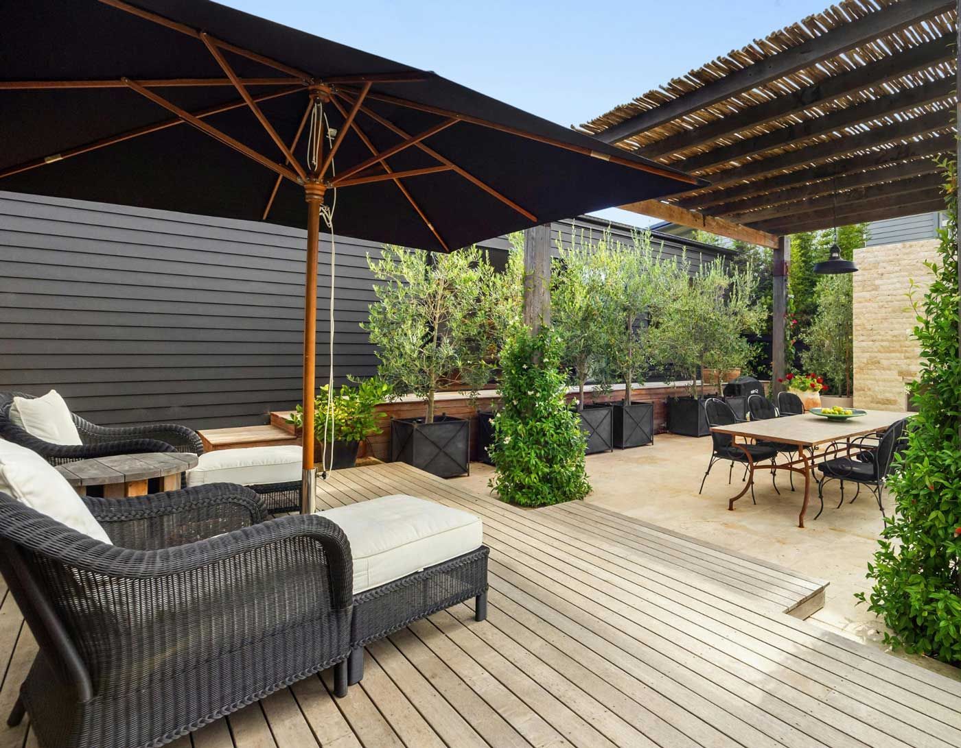 A patio with a table , chairs and umbrellas