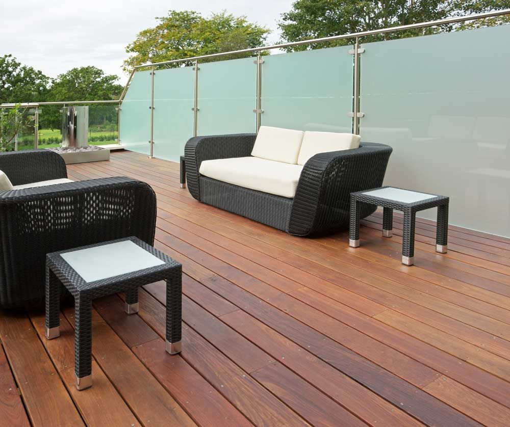 A wooden deck with a couch and chairs on it