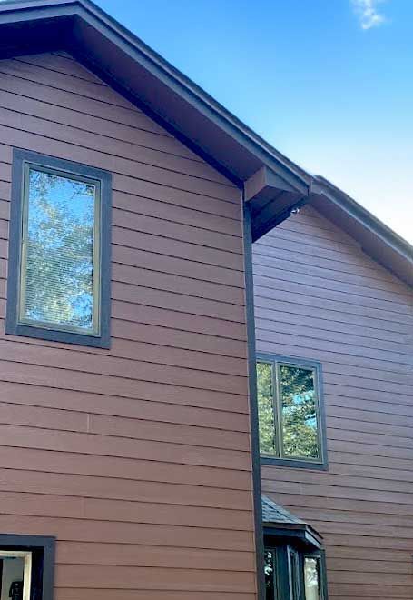Brown siding on a house with windows.