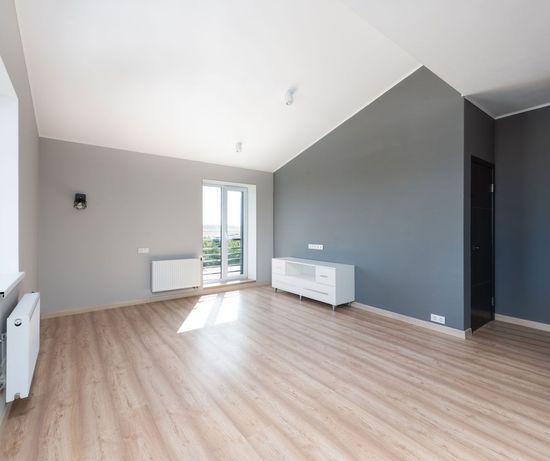 An empty living room with hardwood floors and painted walls.
