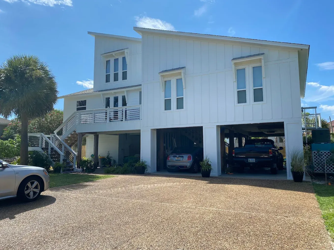 A white house with a car parked in front of it.