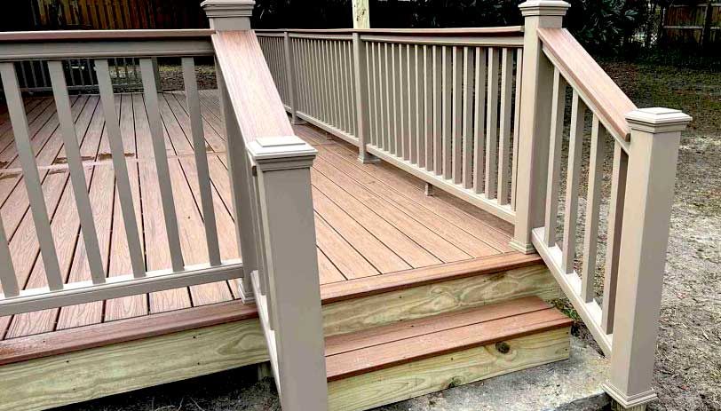 A wooden deck with stairs and a white railing.