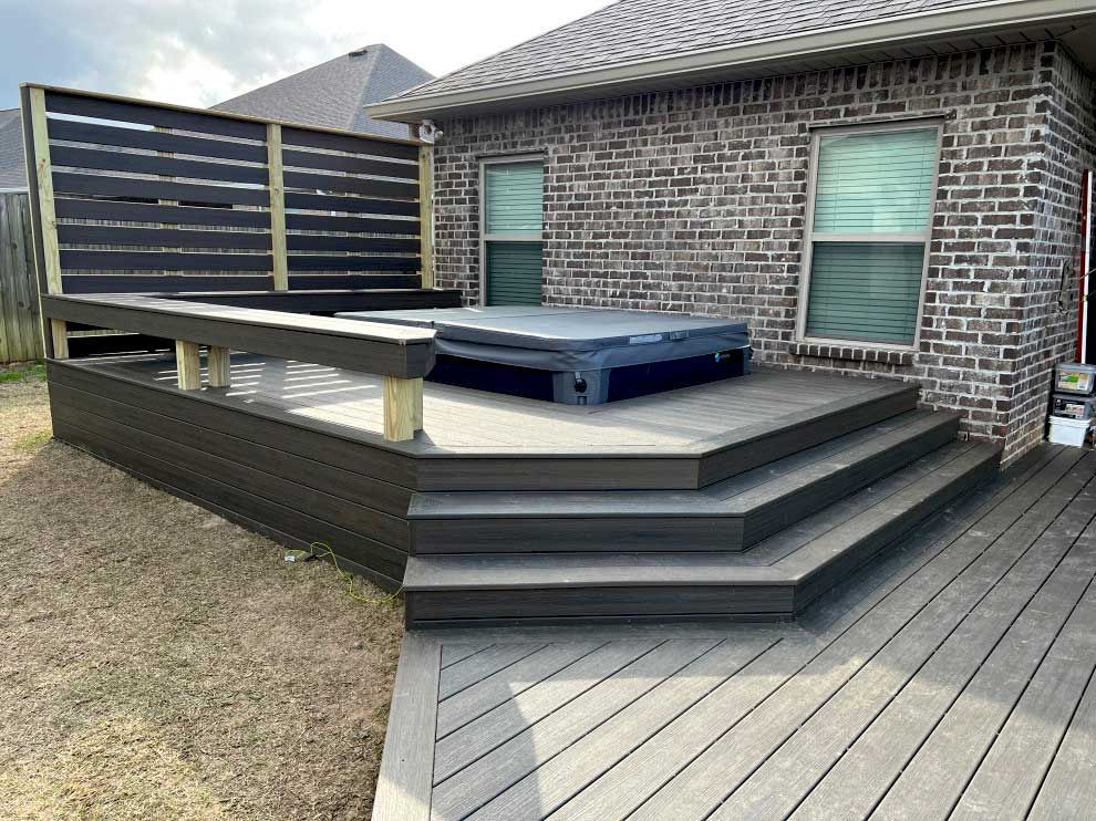 Hot tub built into a deck with stairs.