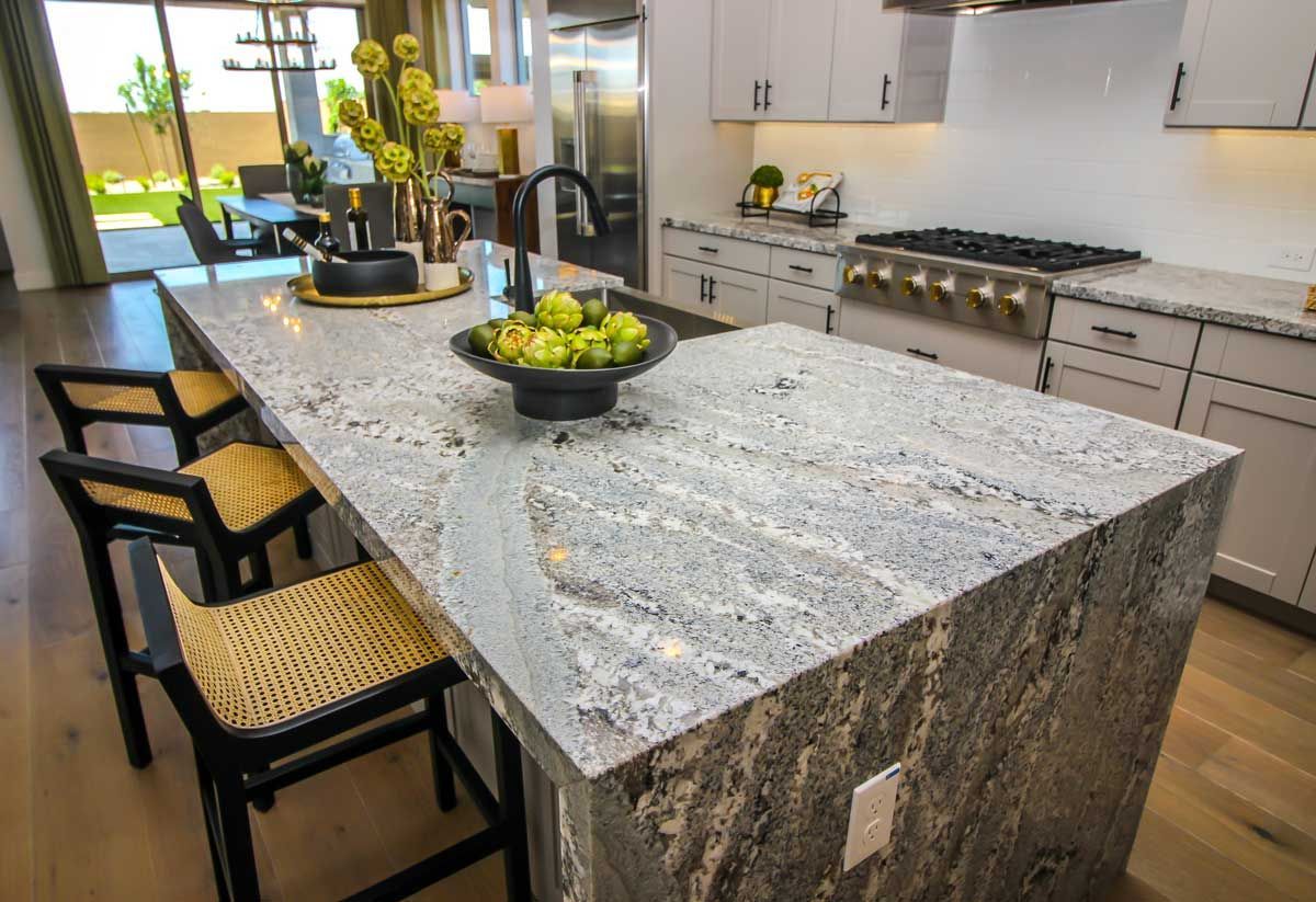 A kitchen with a large island and a bowl of grapes on it.