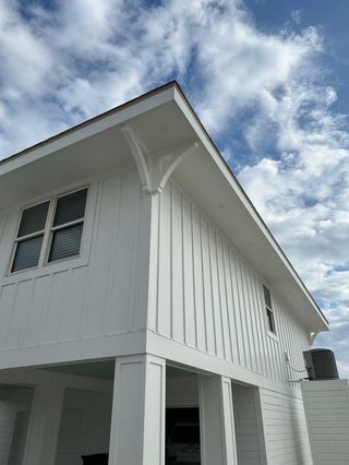 A white house with a blue sky and clouds in the background.