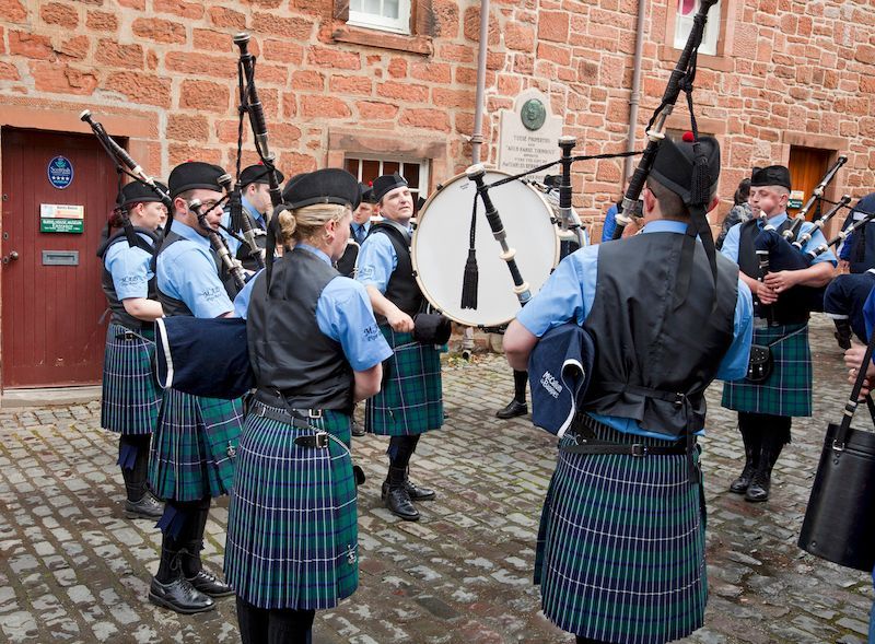 The Muirkirk and District Pipe Band playing outside the Burns House Museum in Mauchline