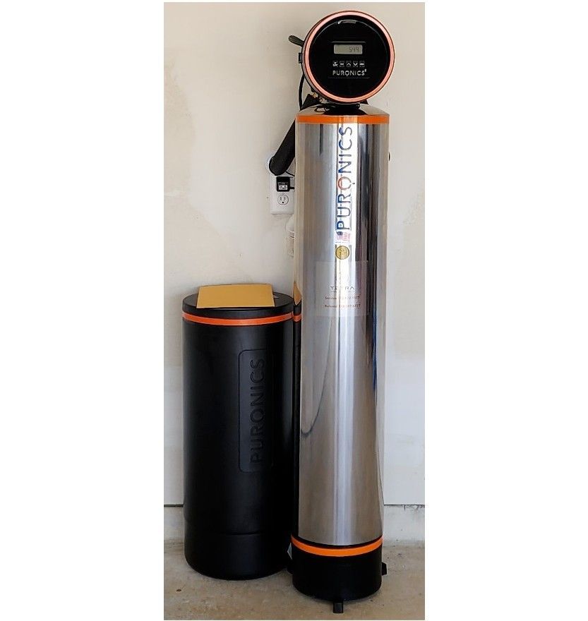 A stainless steel water filter is next to a black tank