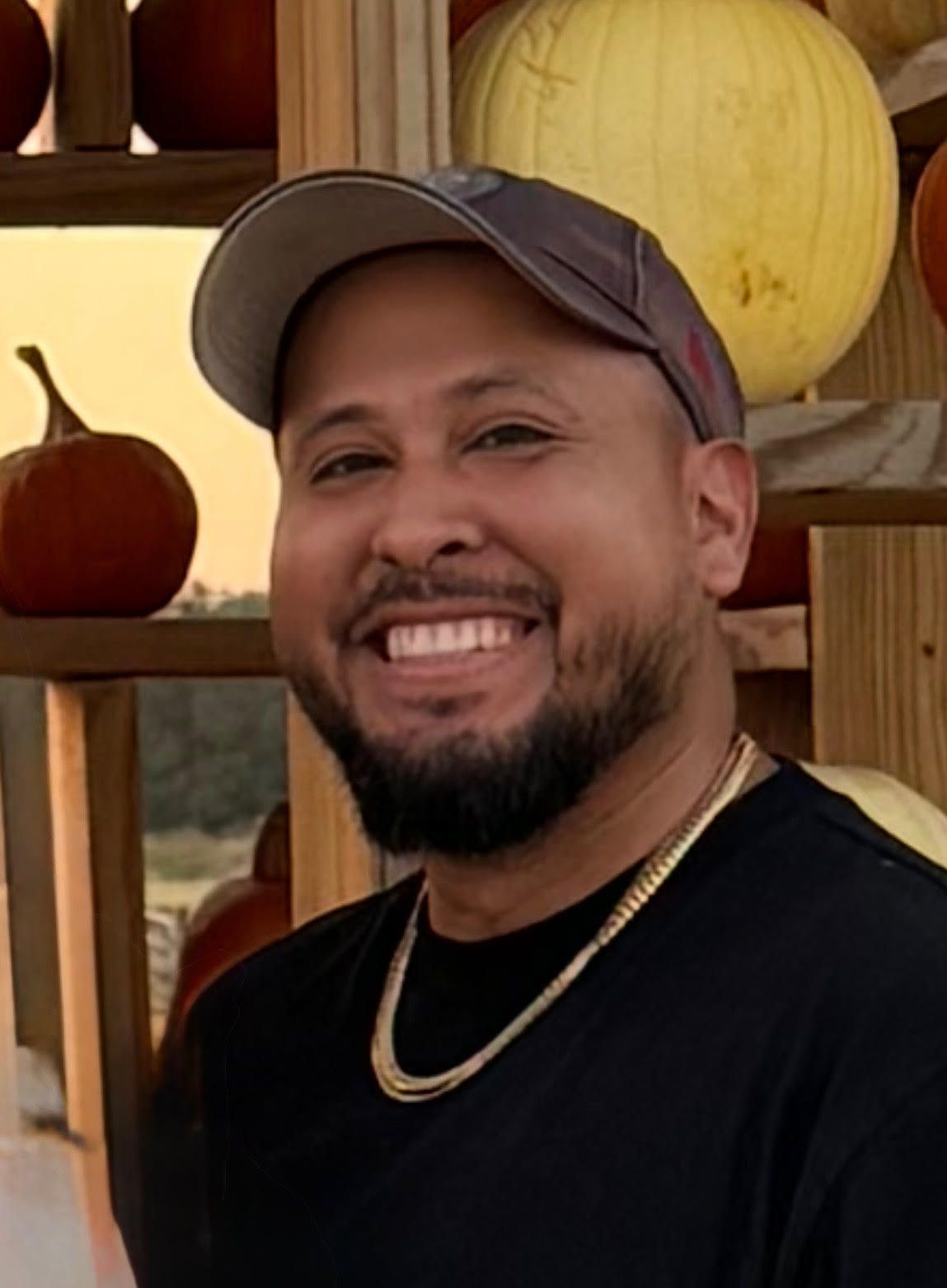 Woman with crossed arms, wearing a gray shirt with 