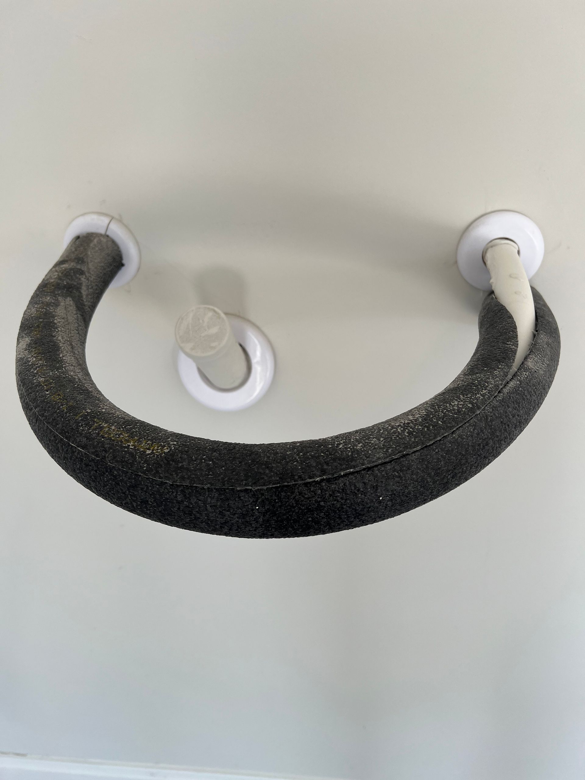 A black pipe is hanging from the ceiling of a room.