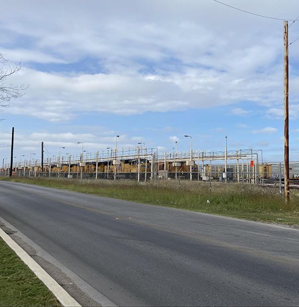 A row of buses are parked on the side of the road