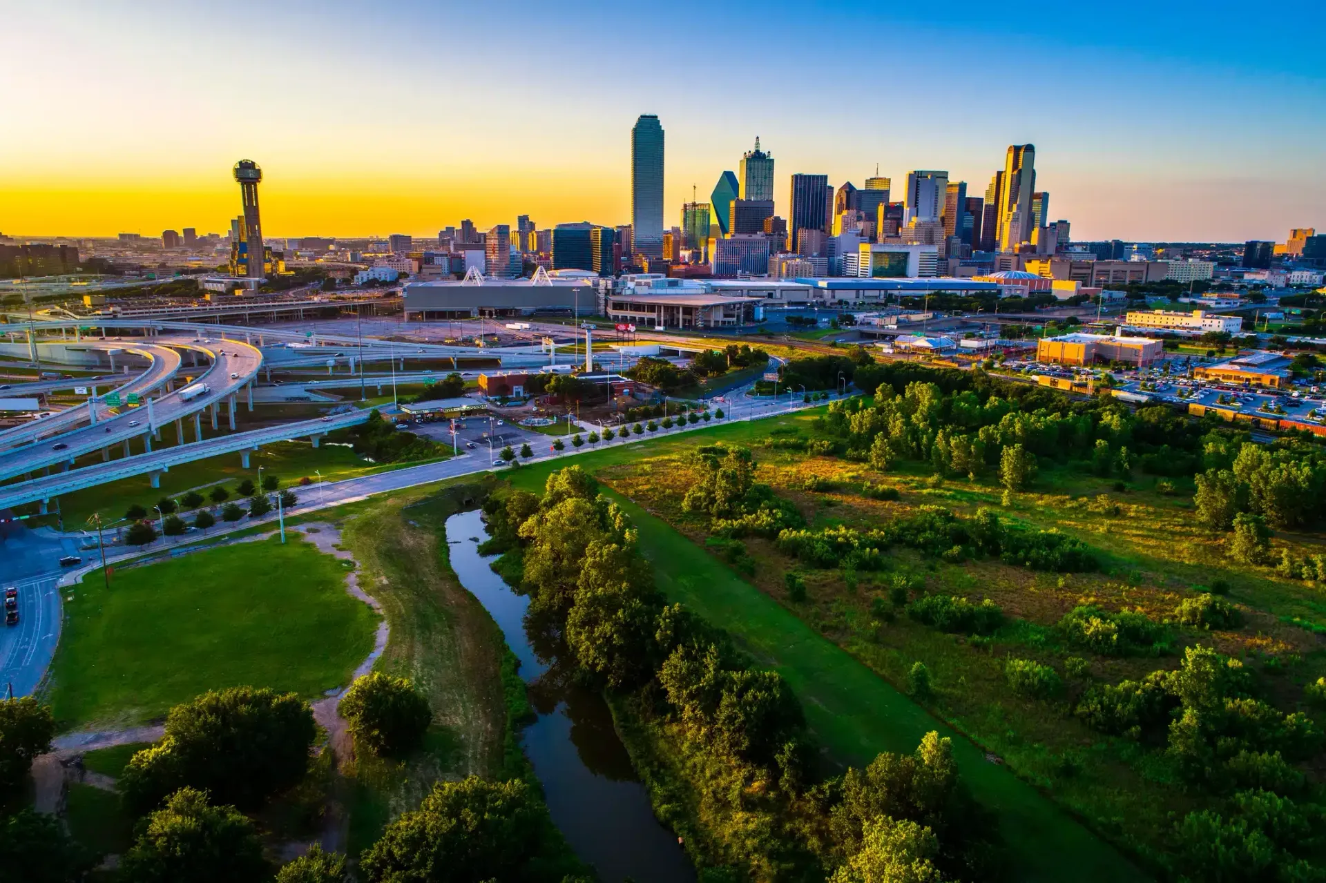 An aerial view of a city skyline with a river in the foreground.