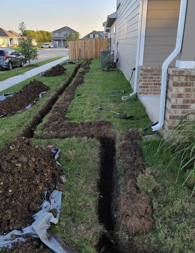 A drainage system is being installed on the side of a house.