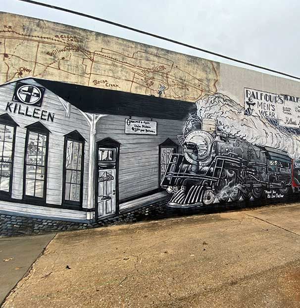 There is a mural of a train on the side of a building.