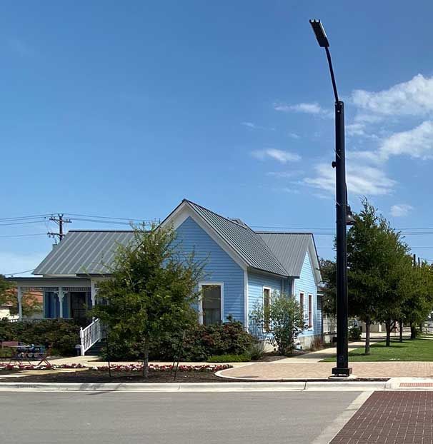 A blue house sits on the corner of a street