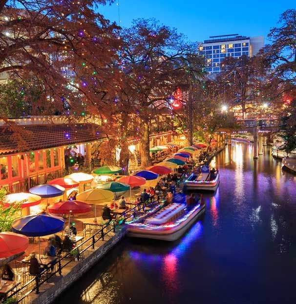 A river with boats and umbrellas on the side of it