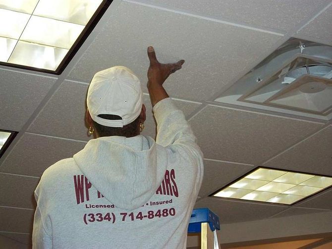 man replacing ceiling tiles